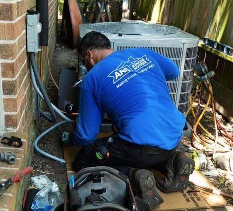 Technician inspecting the service connections of a residential air conditioner
